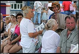 Alušta (Алушта) - ruch u autobusového nádraží, paní nabízí ubytování, do toho jiný pán hraje na harmoniku