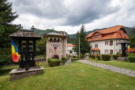 Zvonice pravoslavného kostela, v pozadí vyhlídková skála Piatra Șoimilor (2024)