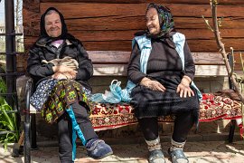 Místní babičky si vykládají na lavičce před domem (2025)