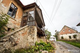 Rozpadlé budovy v obci Kyjatice, v pozadí vykukuje udržovaný obecní úřad (2015)