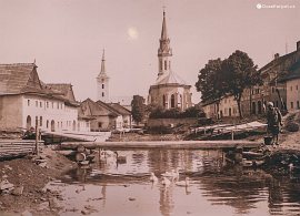 Historické foto: náměstí s měšťanskými domy a dva ruskinovské kostely. Zdroj: infotabule v kostele.