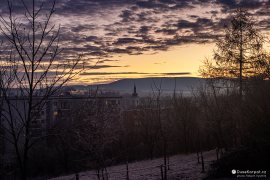 Mezi paneláky vykukuje špička římskokatolického kostela Nanebevzetí Panny Marie (2023)